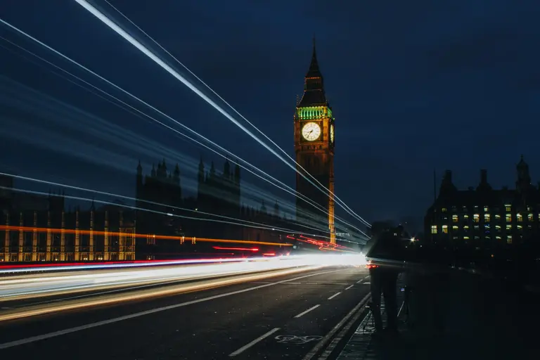 Traffic light trails streaking past the Elizabeth Tower in London at night